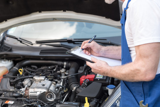 Car mechanic checking a car engine